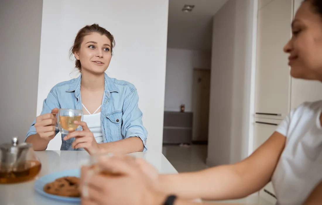 Two people talking over tea at a kitchen table